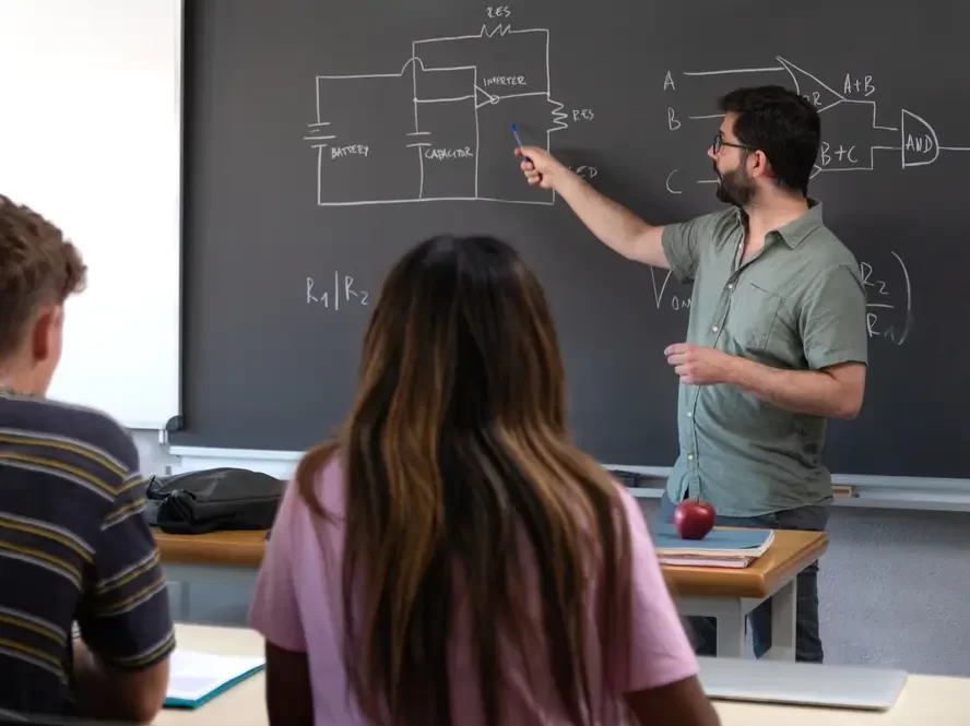 Profesor učí a stojí u tabule