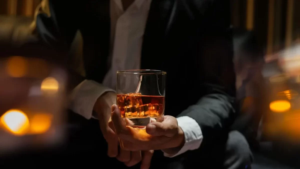 Muž drží láhev s whiskey