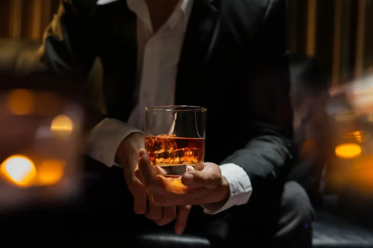 Muž drží láhev s whiskey
