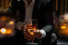 Muž drží láhev s whiskey