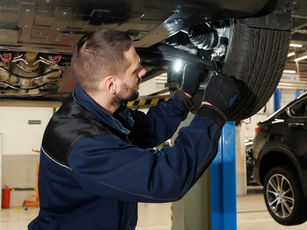 shutterstock_2493428873 - Techsvět Mechanik kontroluje podvozek vozidla