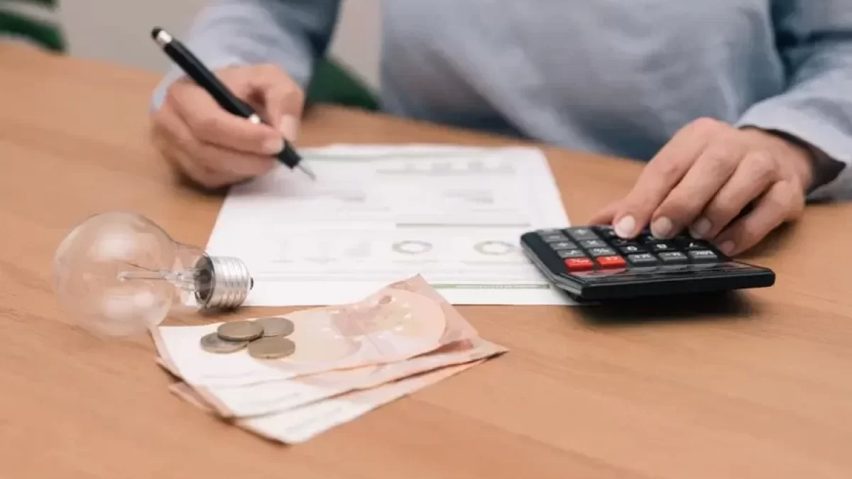 Počítání výdajů za elektřinu a stará žárovka na stole