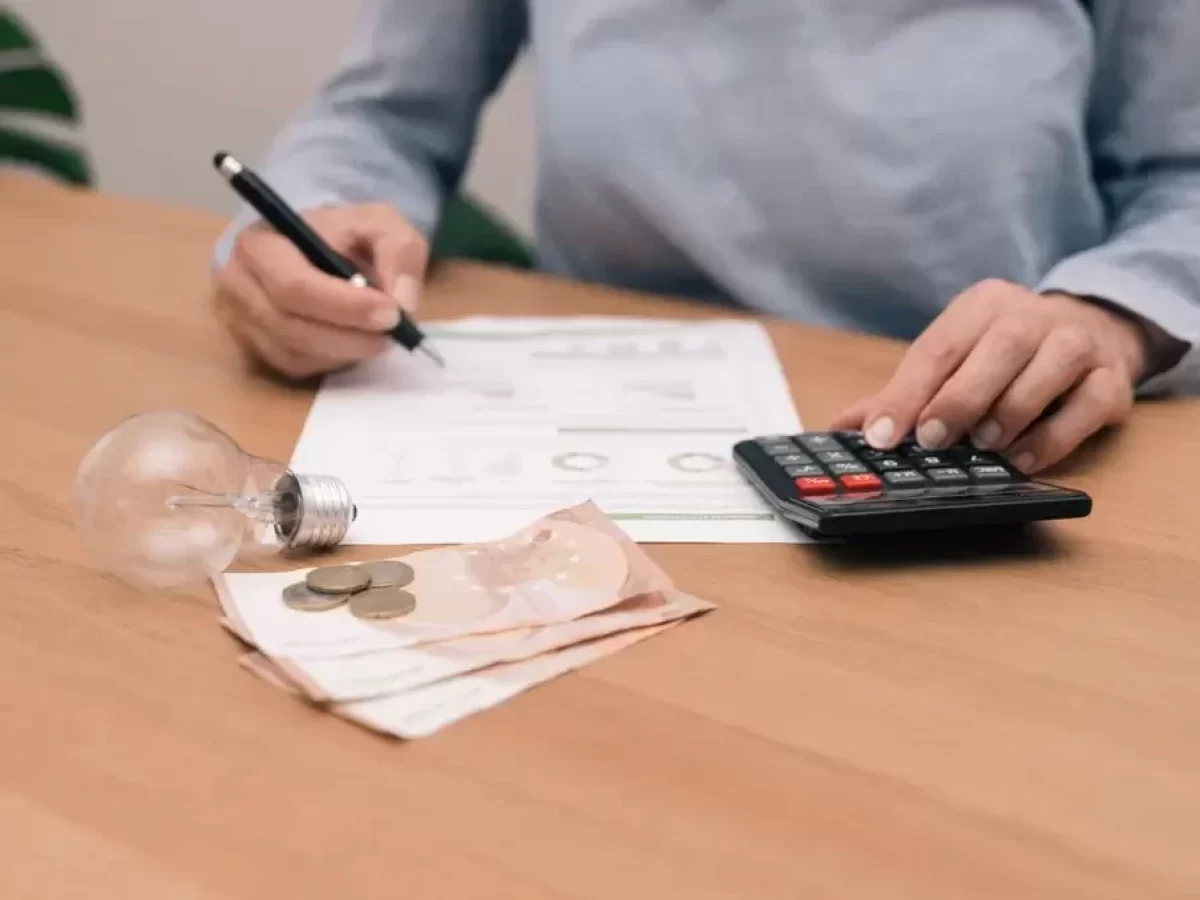 Počítání výdajů za elektřinu a stará žárovka na stole