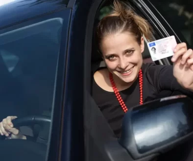 Spokojená žena za volantem ukazující řidičák