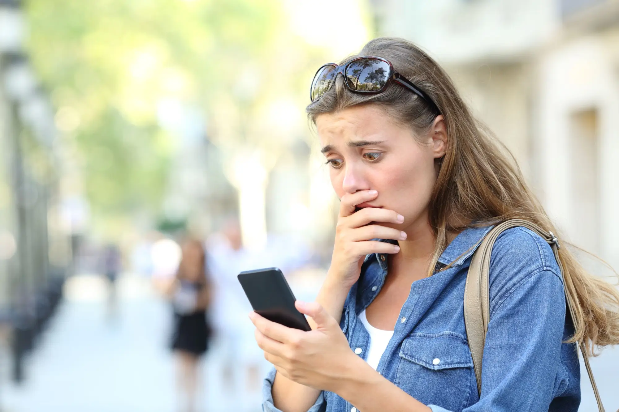 Překvapená žena sleduje něco v telefonu