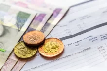 české peníze s účty za elektřinu
