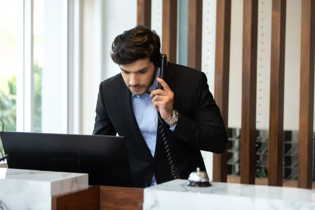 muž pracující na recepci telefonuje