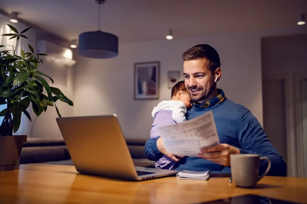 - Techsvět muž se spícím miminkem na rameni u počítače