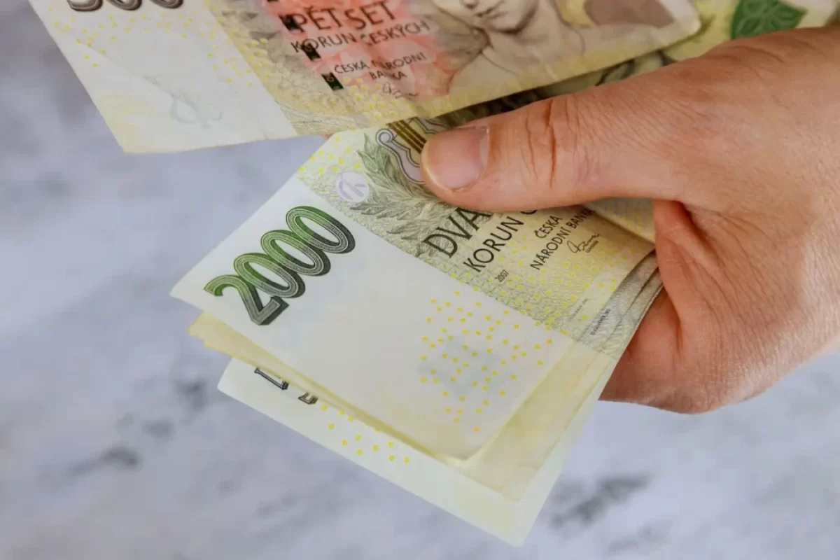 Muž drží v ruce dvoutisícové bankovky