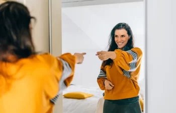 žena se na sebe usmívá do zrcadla