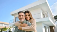 Žena a muž stojí u svého nového domu