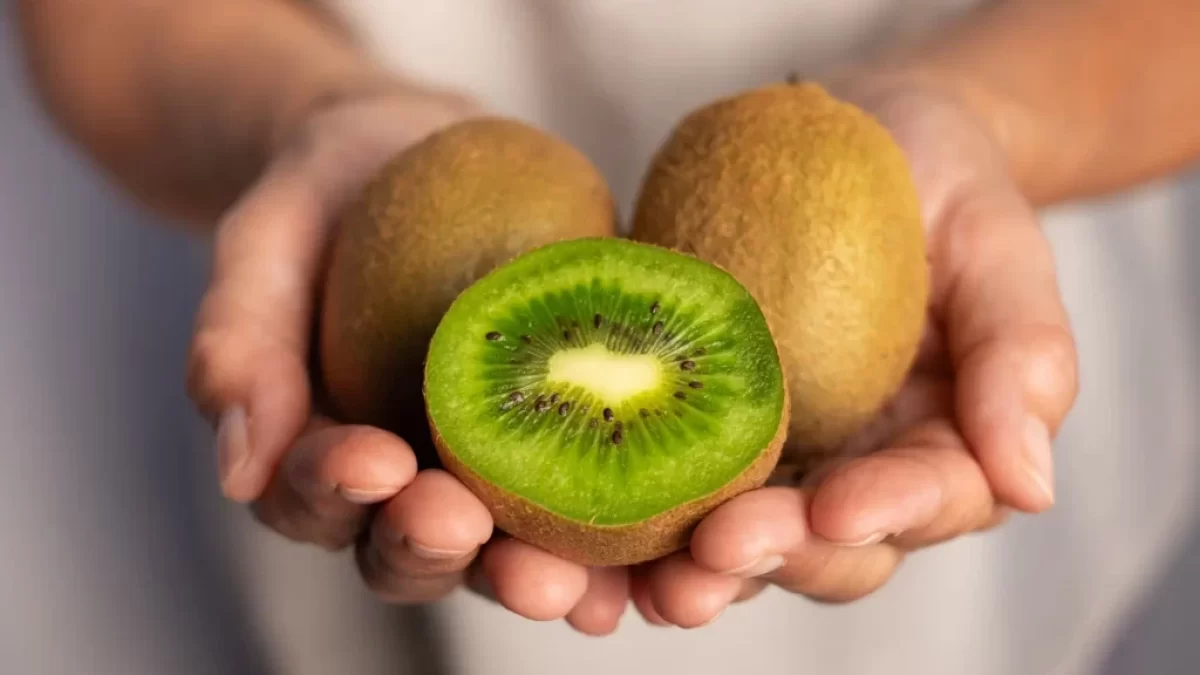 žena drží v ruce zdravé ovoce kiwi