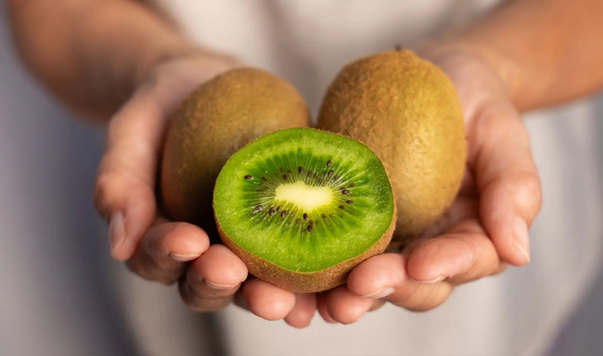 žena drží v ruce zdravé ovoce kiwi