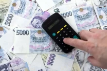 muž s kalkulačkou počítá peníze