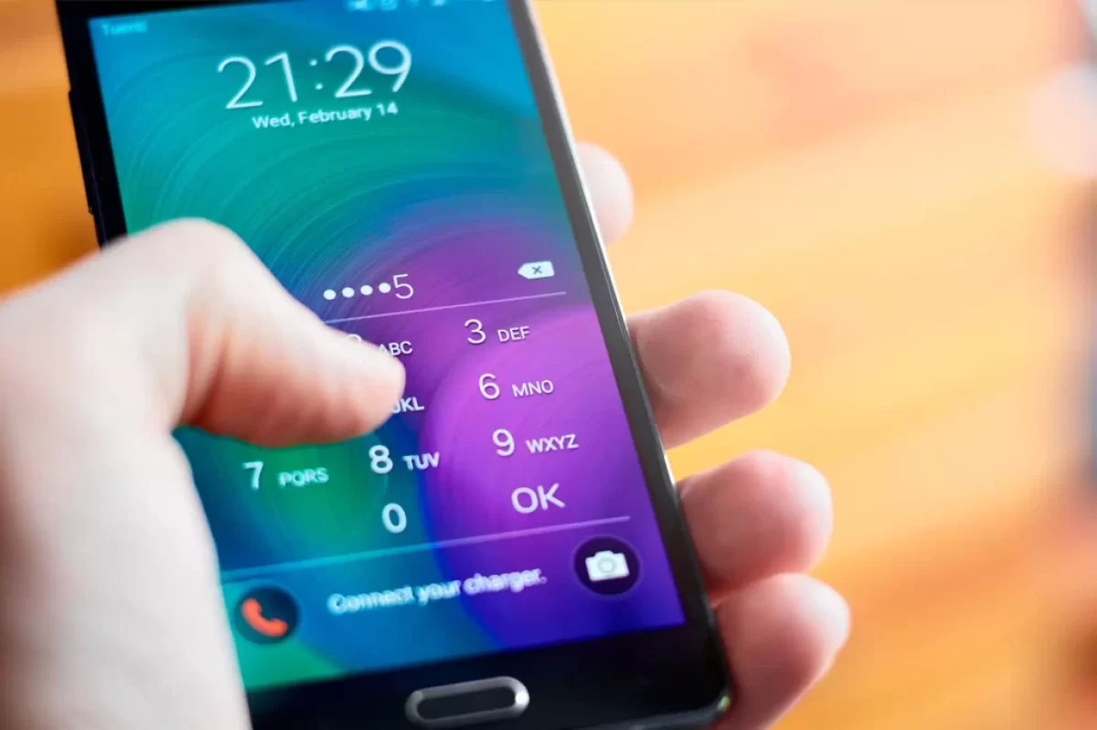 muž zadává PIN v telefonu