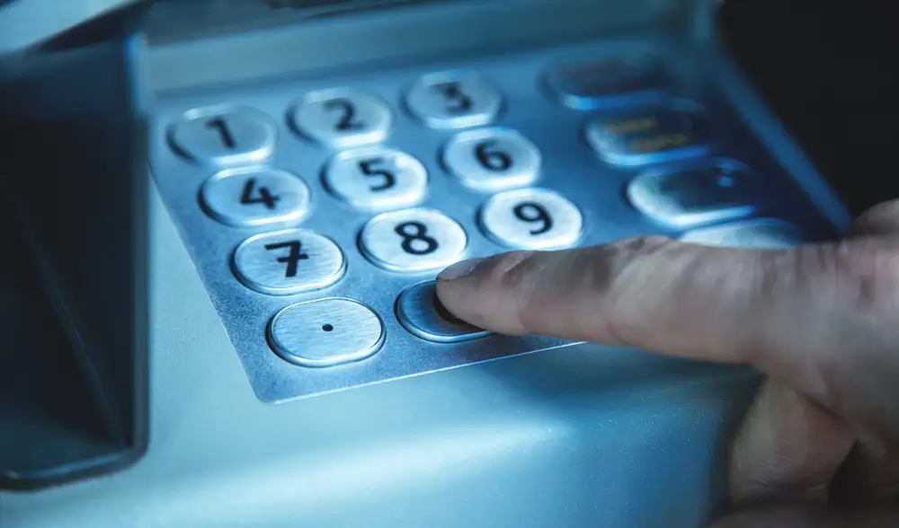 Tohle tlačítko vás u bankomatu ochrání - Techsvět Muž mačká tlačítko na bankomatu
