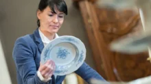 odbornice zkoumá hodnotu porcelánového talíře