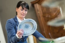 odbornice zkoumá hodnotu porcelánového talíře