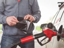 Muž s peněženkou tankuje