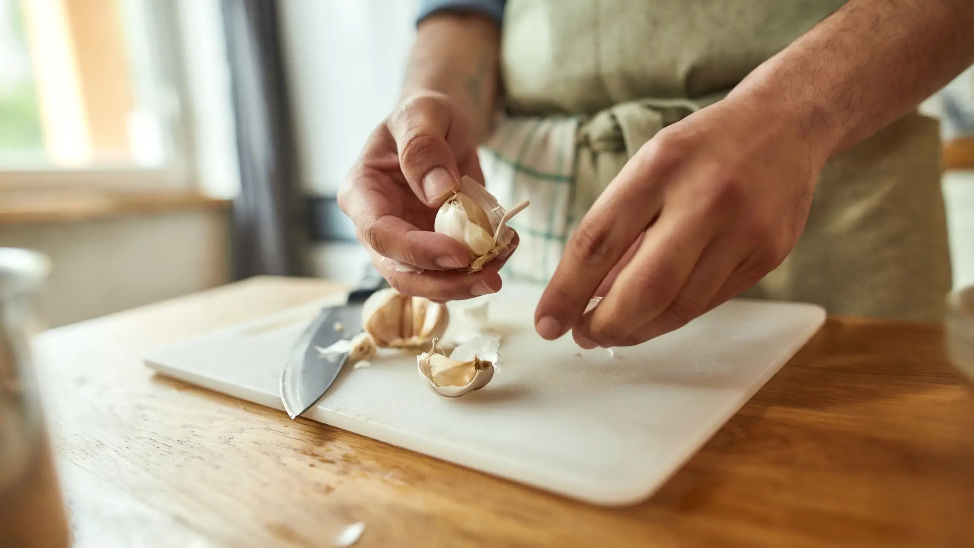 Shutterstock_1805181946 - Techsvět Žena v kuchyni loupe česnek