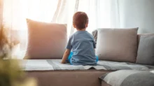 Osamělý chlapec sedí na gauči
