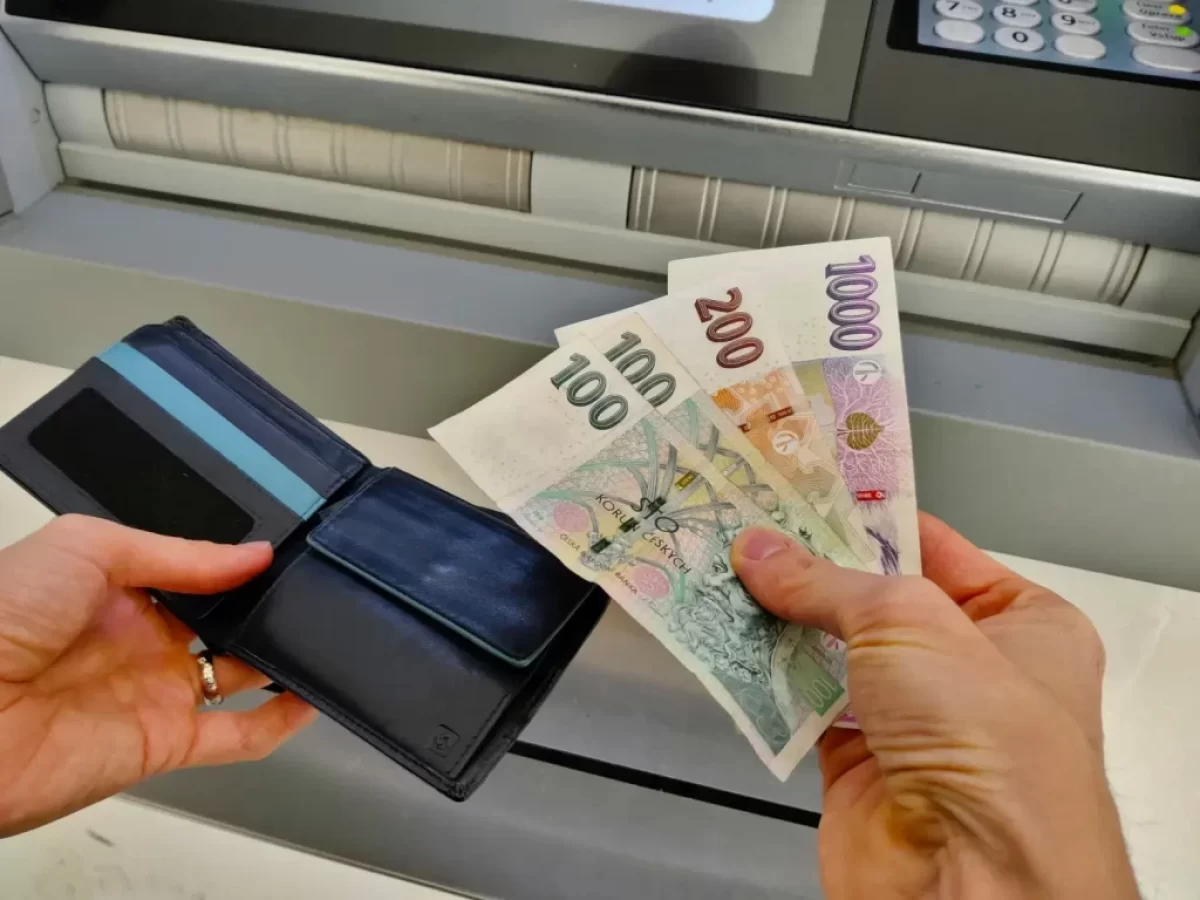 muž vybírá peníze z bankomatu