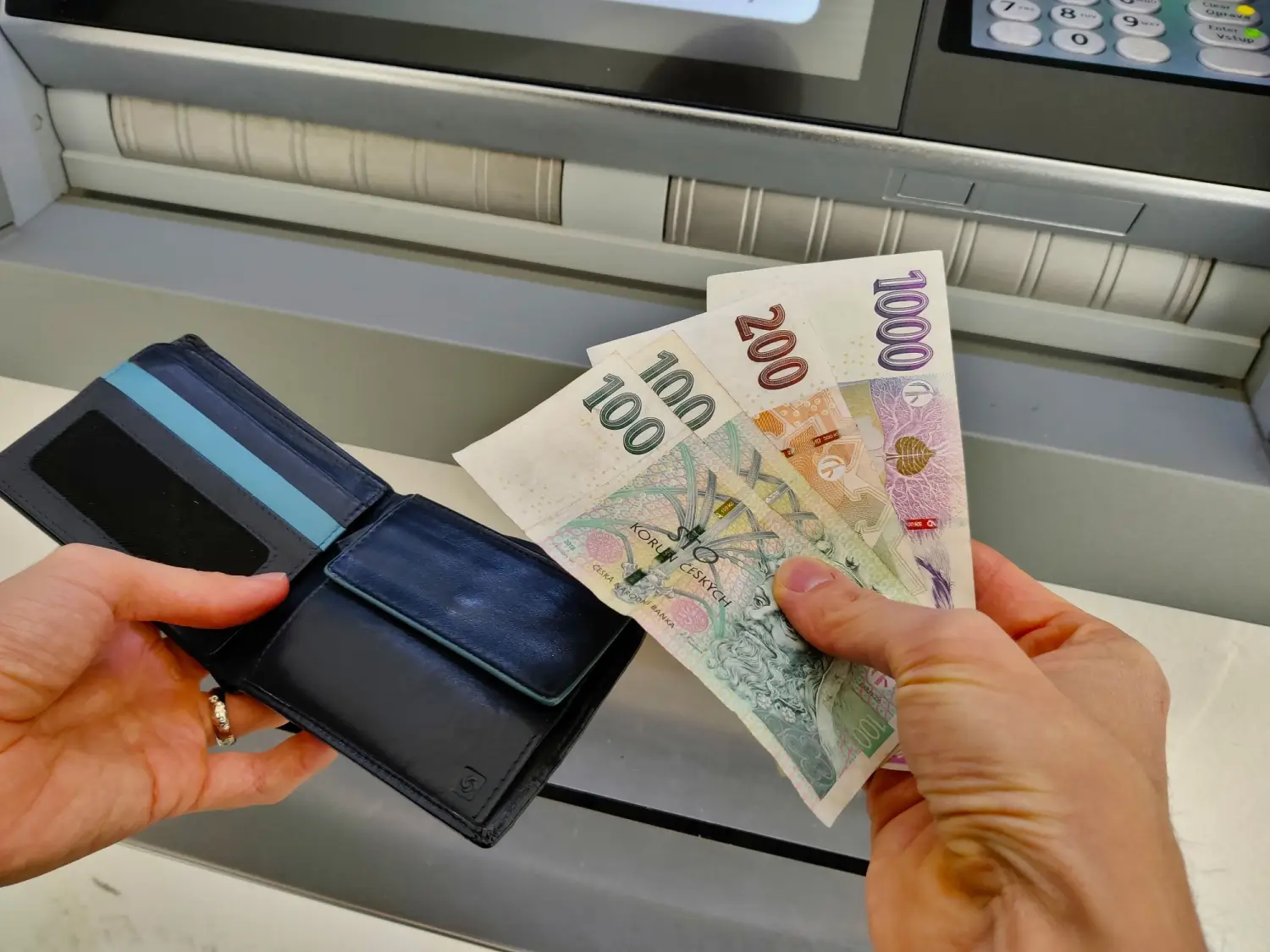 muž vybírá peníze z bankomatu