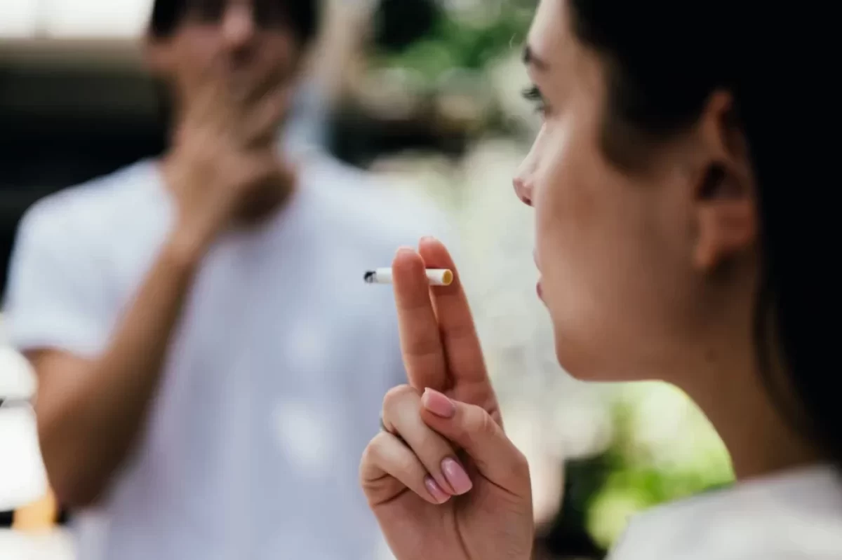 Žena kouří cigaretu spolu s kamarádem
