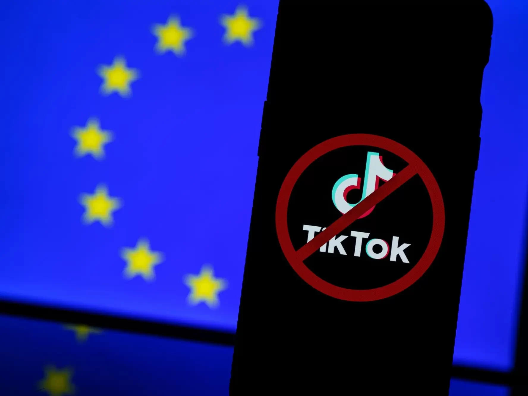 Telefon, vlajka EU a logo TikTok přeškrtnuté