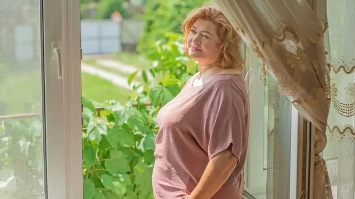 žena stojí u okna