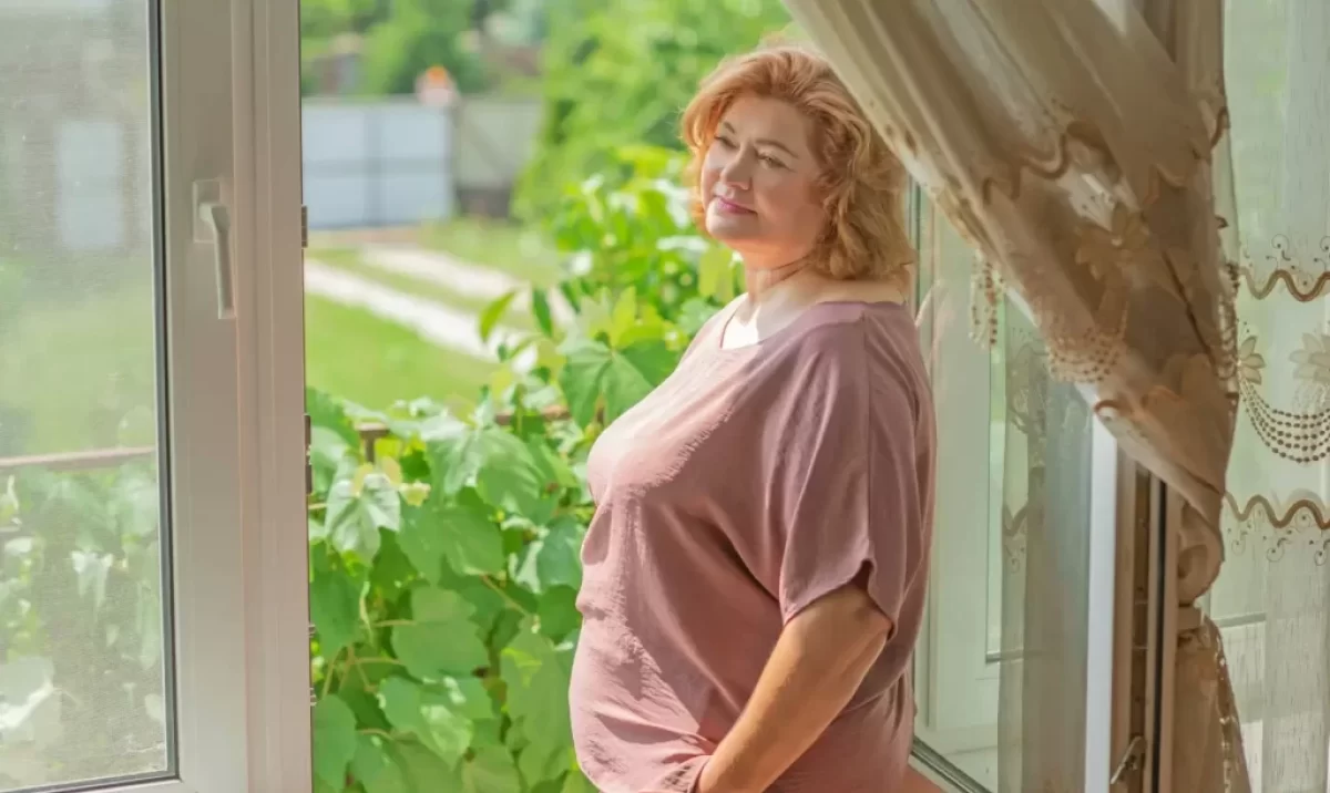 žena stojí u okna