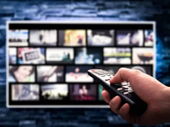 Ruka s ovladačem u TV