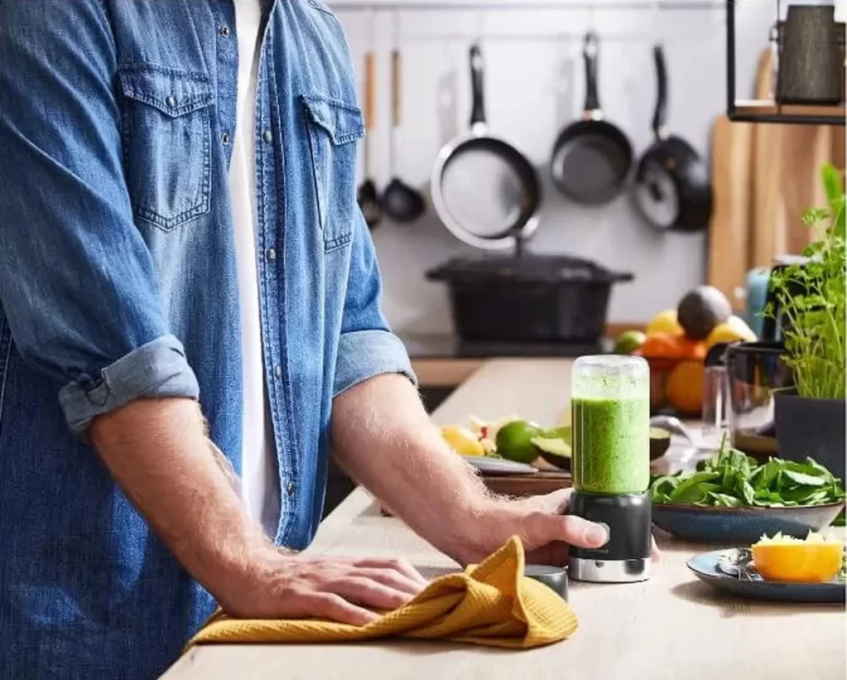 muž si dělá zelené smoothie v mixéru