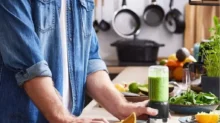 muž si dělá zelené smoothie v mixéru