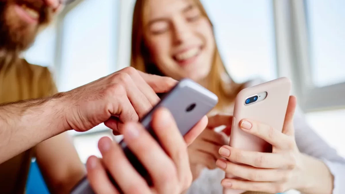 mladý pár se směje u telefonu