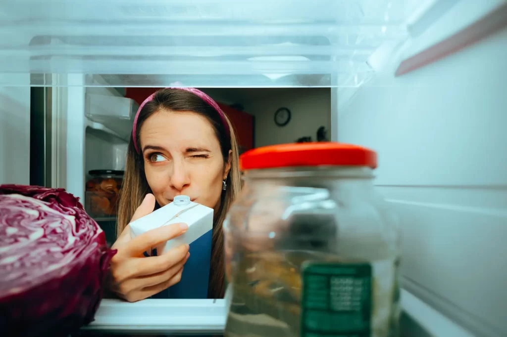 žena čichá ke krabici mléka
