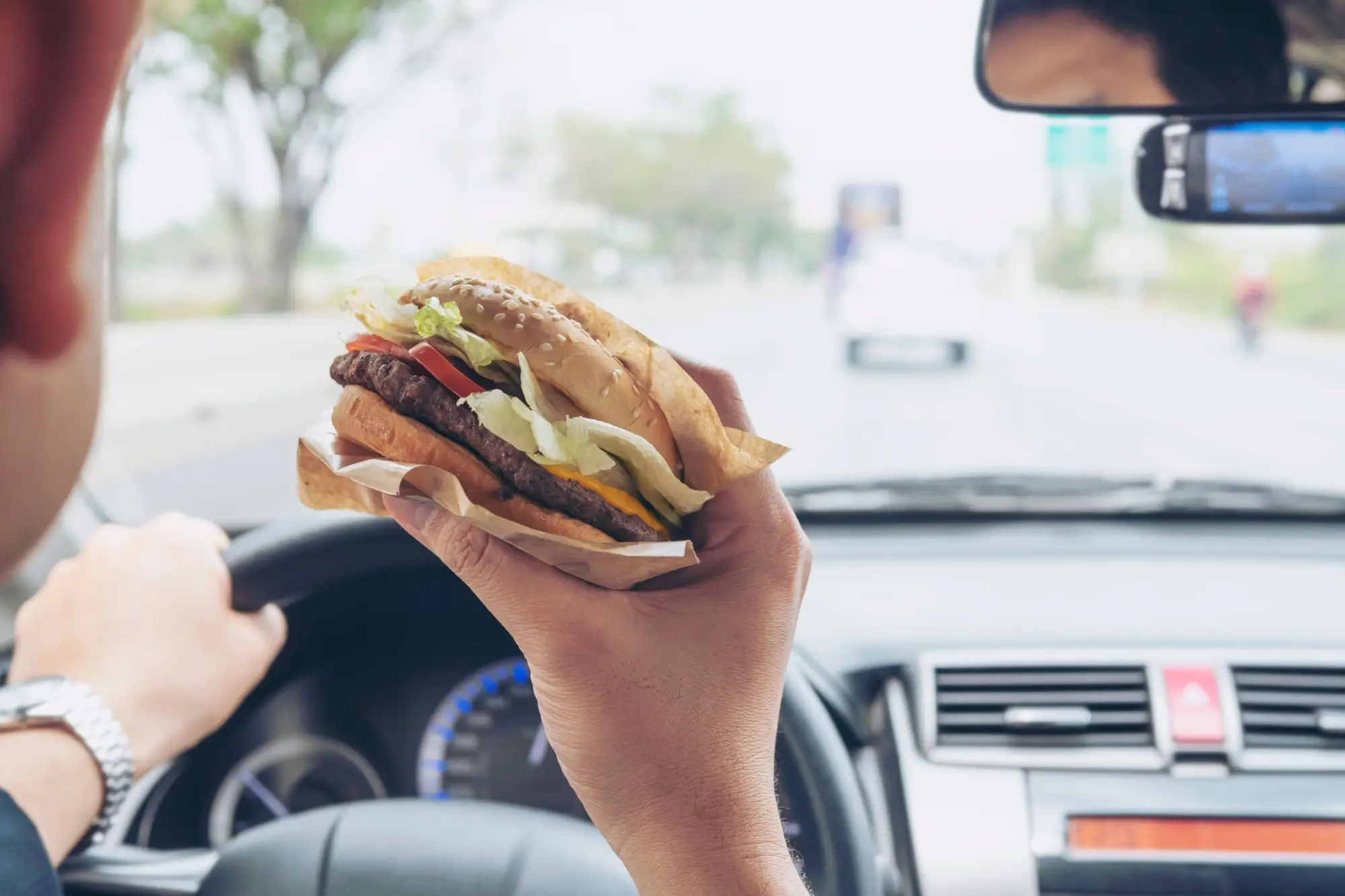Řidič jí burger za jízdy