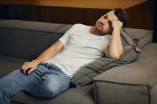 Muž leží na pohovce