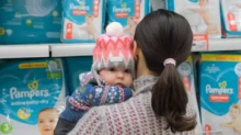Matka s dítětem vybírá plenky