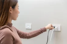 žena vypojuje spotřebič ze zásuvky