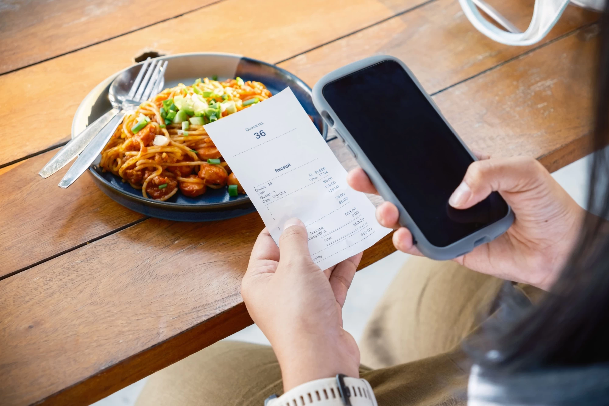 Shutterstock_2409387291 - Techsvět Zákazník kontroluje účtenku v restauraci