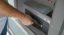 Muž si vybírá hotovost z banky