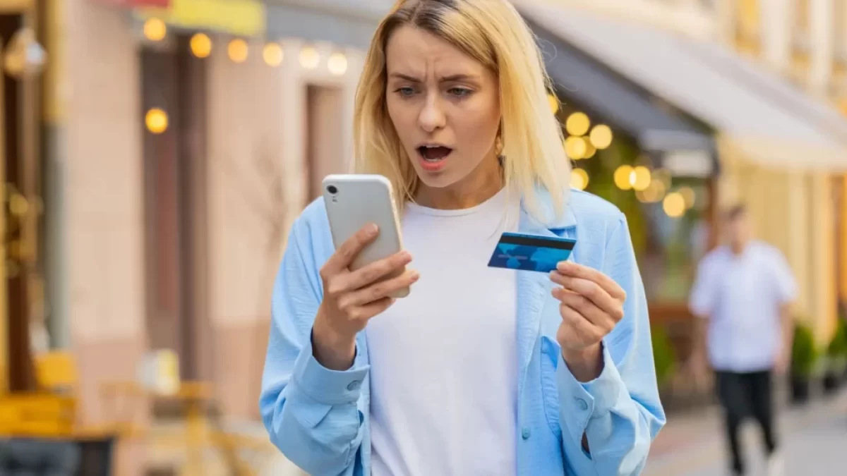 Naštvaná žena s kreditkou a mobilem