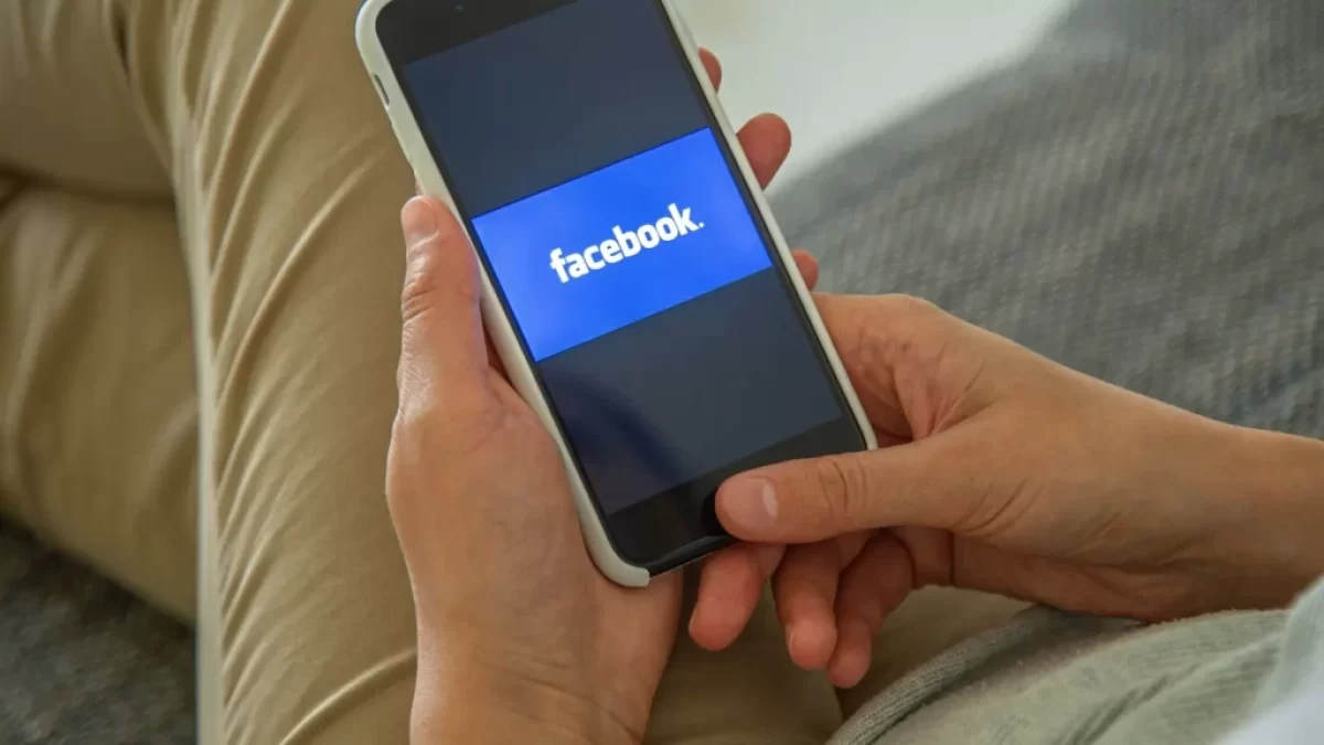 Muž s mobilem a facebookem