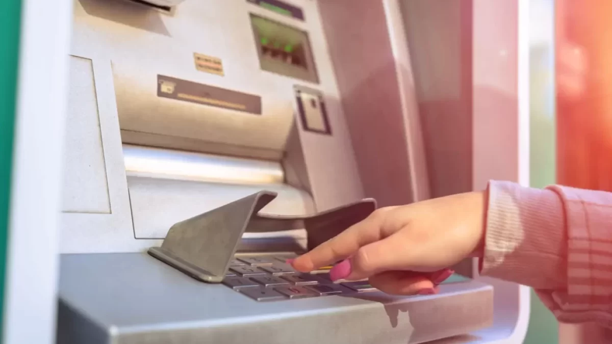Žena vybírá z bankomatu