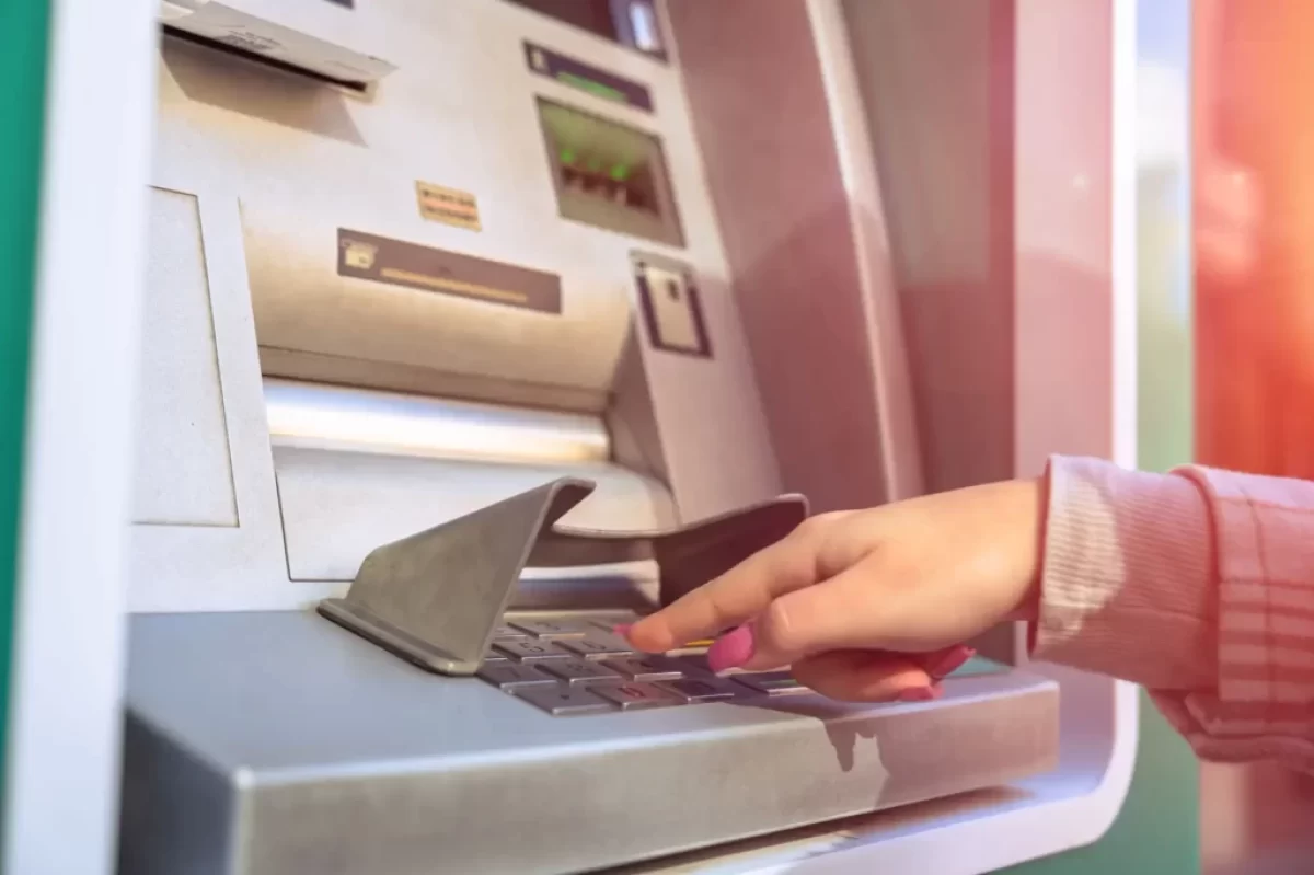 Žena vybírá z bankomatu