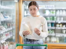 Žena porovnává produkty v obchodě