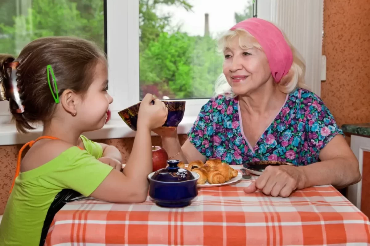 Babička pije čaj s vnučkou.