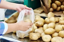 Žena nabírá brambory do sáčku