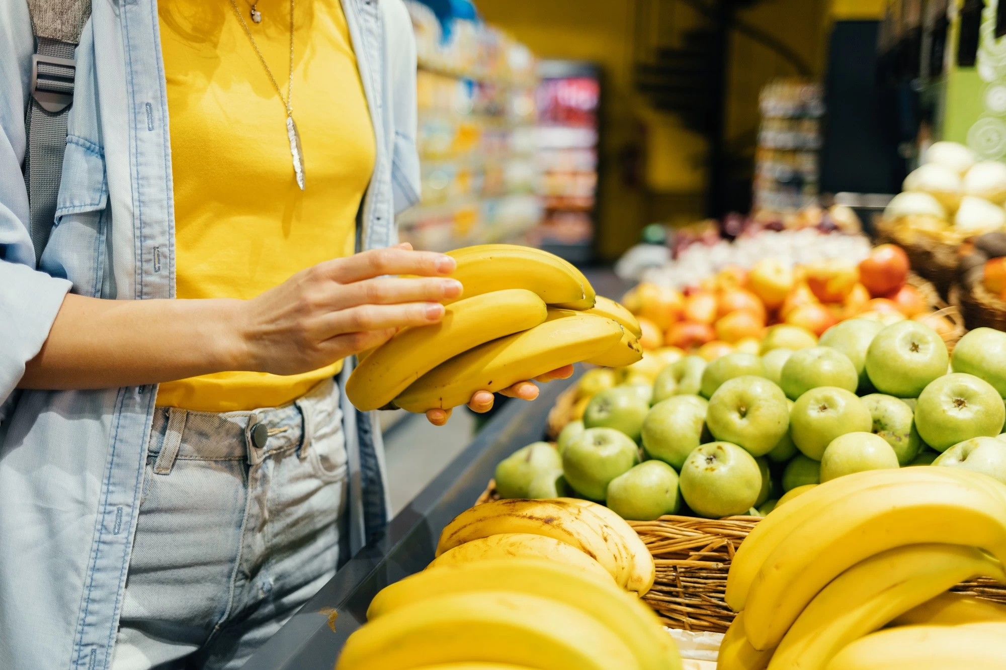 Close-upOfFemaleHandsTakingBananasFromTheStoreShelf - Techsvět žena si prohlíží banány